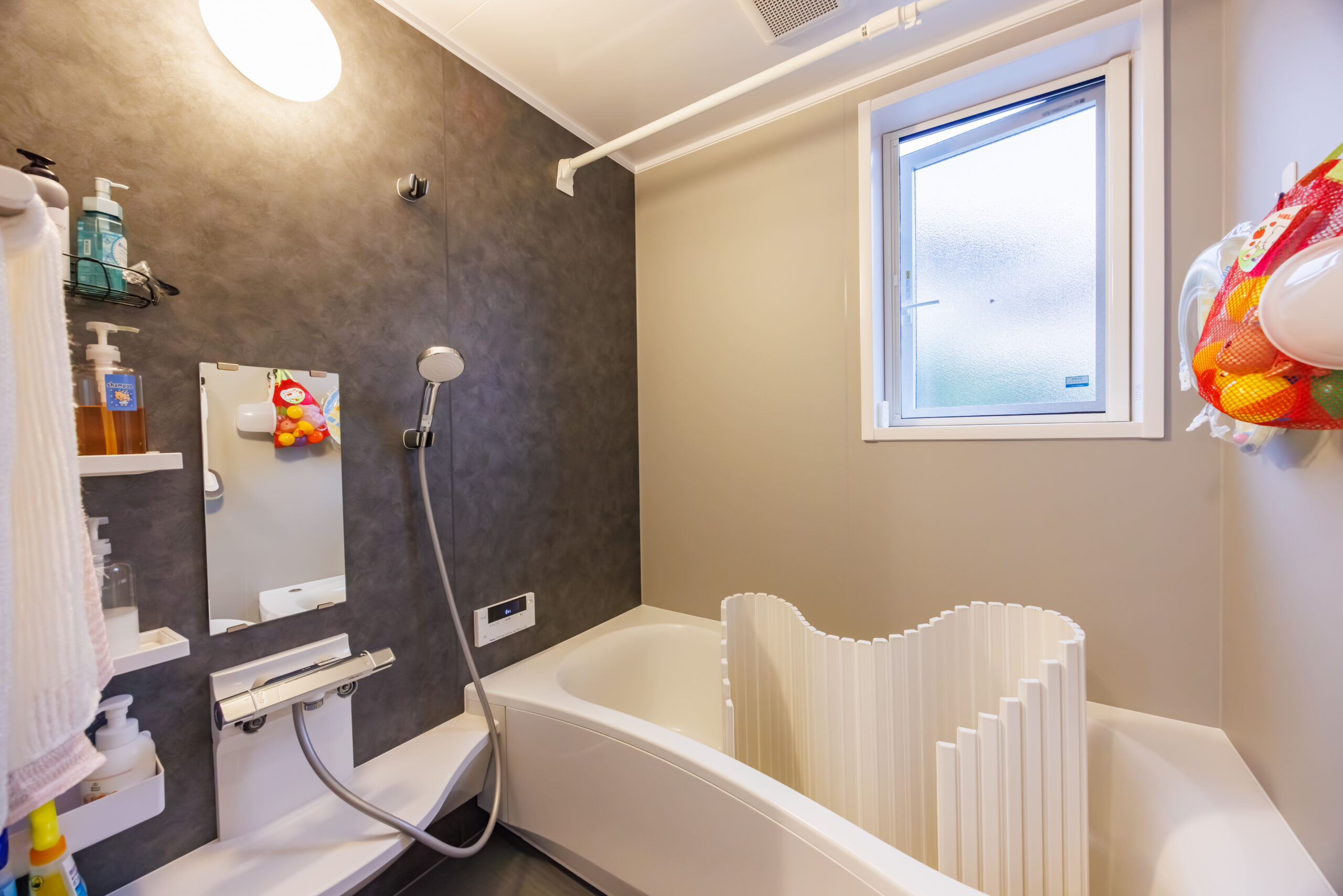 藤枝市の2階建て注文住宅|グレークロスとワイド浴槽でゆったりくつろげる、窓付きバスルーム