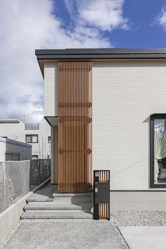 シンプルなホワイトの外壁に木目の格子がアクセント♪